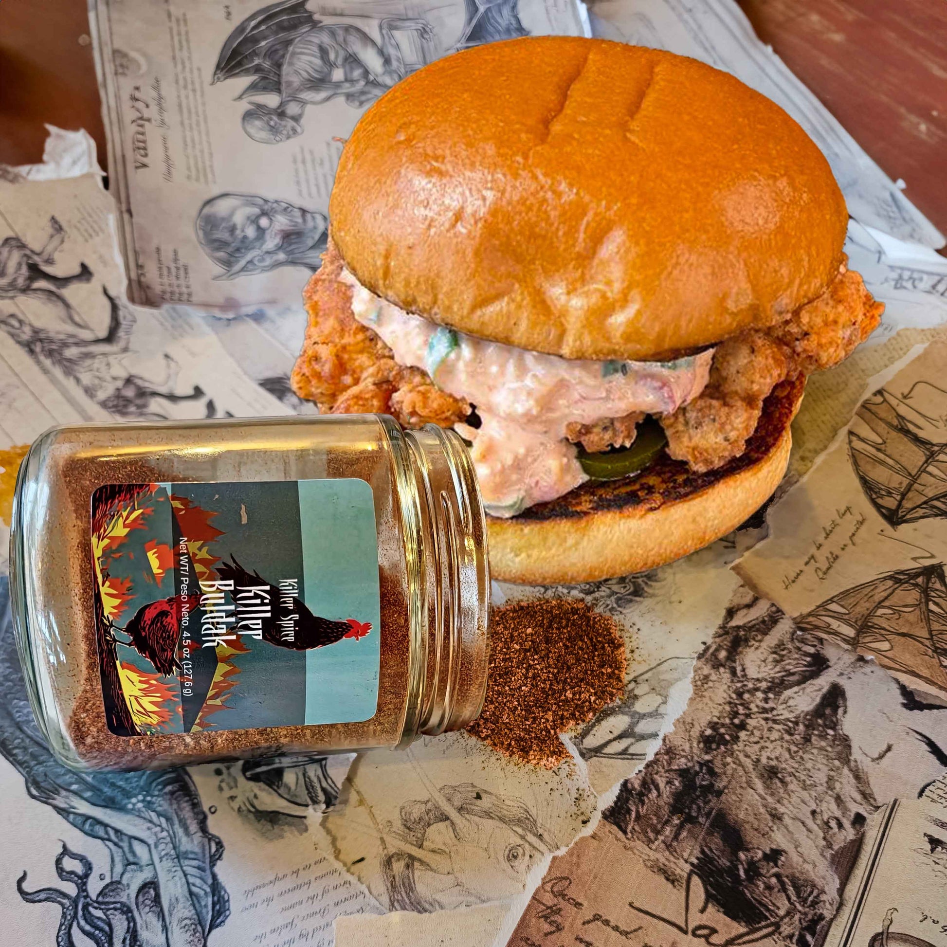 Killer Buldak coffee-infused spice blend jar next to crispy chicken sandwich with spicy sauce on vintage paper background