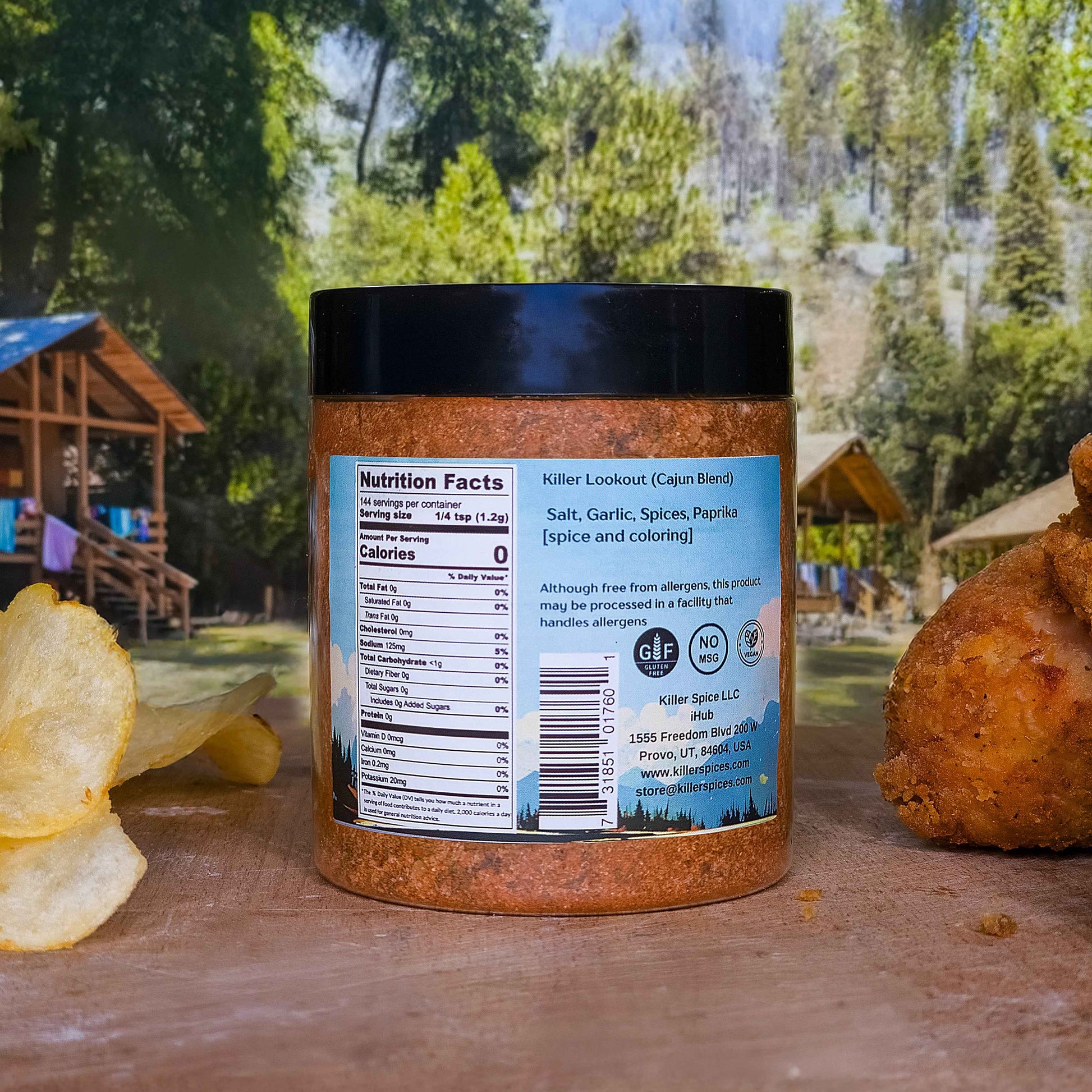 Killer Lookout Cajun spice blend jar displayed outdoors with rustic background and potato chips on wooden surface