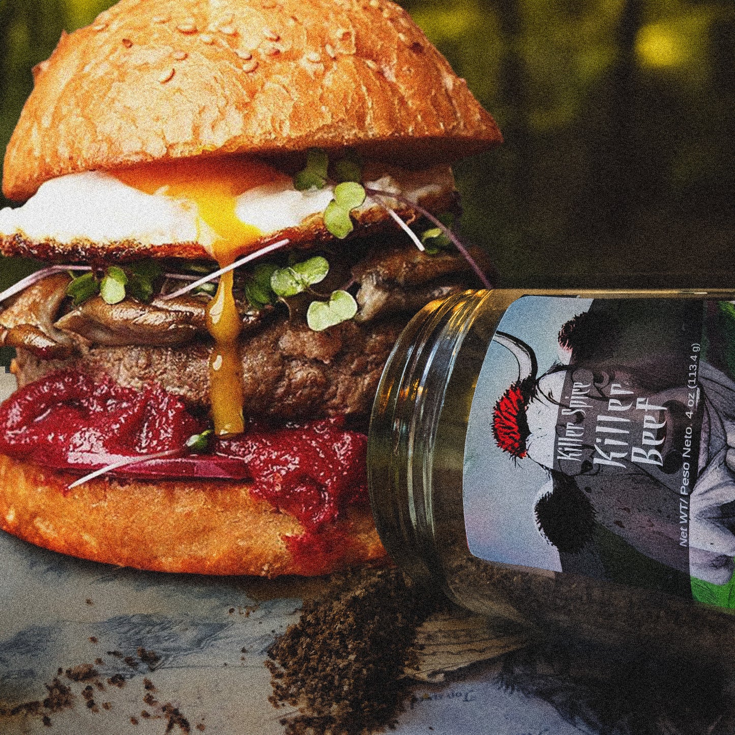 A gourmet burger with a runny egg and microgreens, seasoned with Killer Spice's Killer Beef blend, beside a jar of coffee grounds, presented in an artistic, rustic setting.