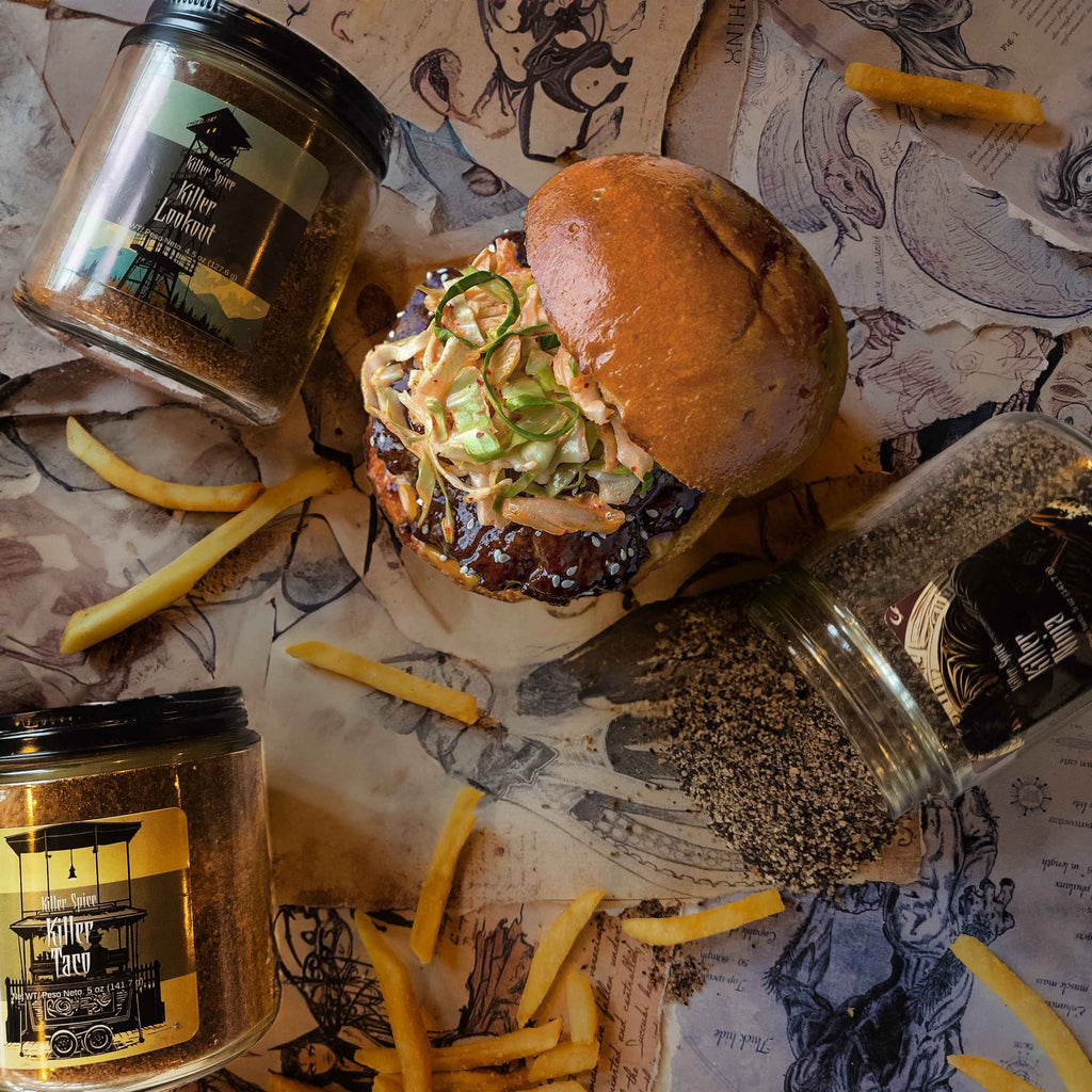 Killer Taco spice jar displayed with juicy burger topped with slaw and french fries on illustrated paper background
