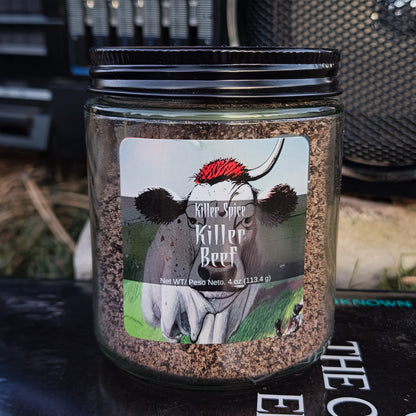 Jar of "Killer Beef (Infused Coffee, Garlic Rub)" by Killer Spice on a surface with objects in the background.