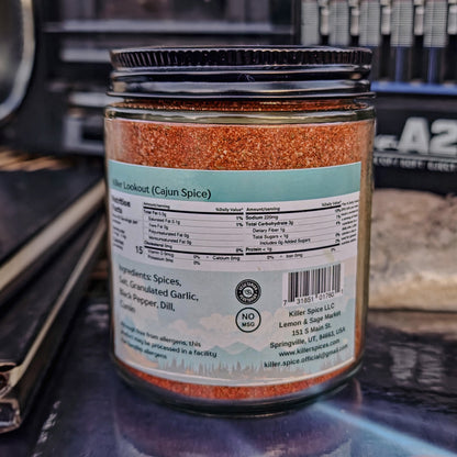 A jar of Killer Spice's Killer Lookout Cajun Spice blend on a shelf displaying nutritional information and ingredients.
