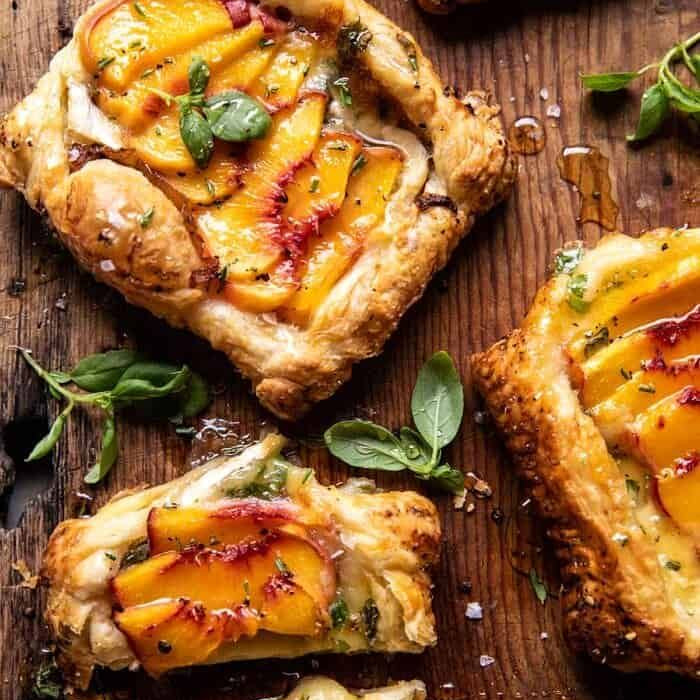 Peach tarts on a wooden board with fresh basil leaves