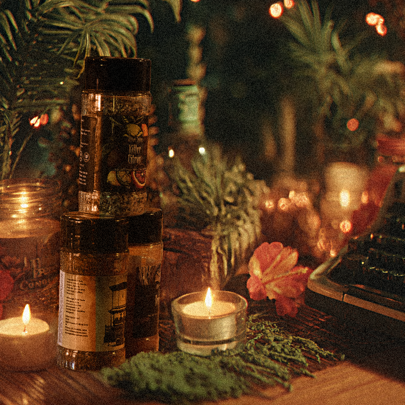 Vintage typewriter on a table with candles, bottles, and decorative plants in a warm, cozy setting.