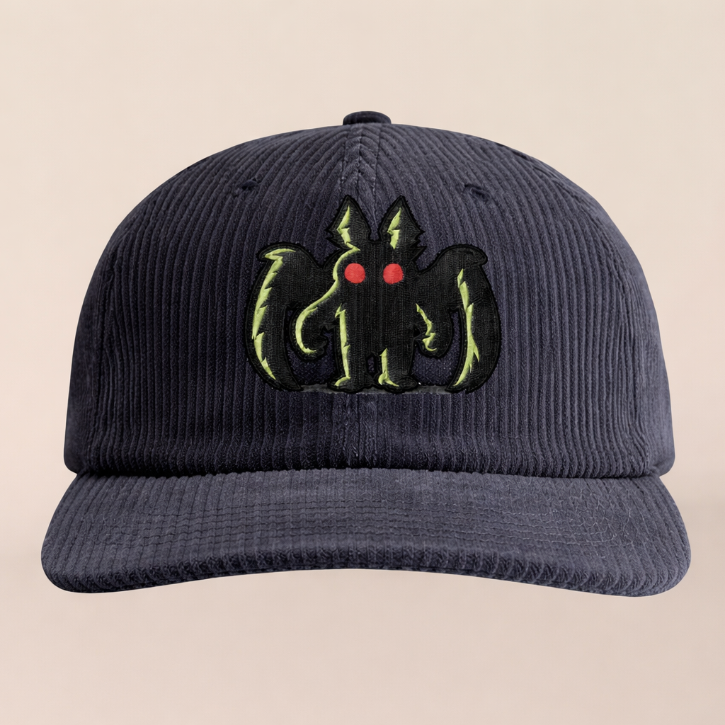 Black cap with embroidered design on a beige background